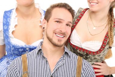 Mann in Tracht mit zwei Frauen